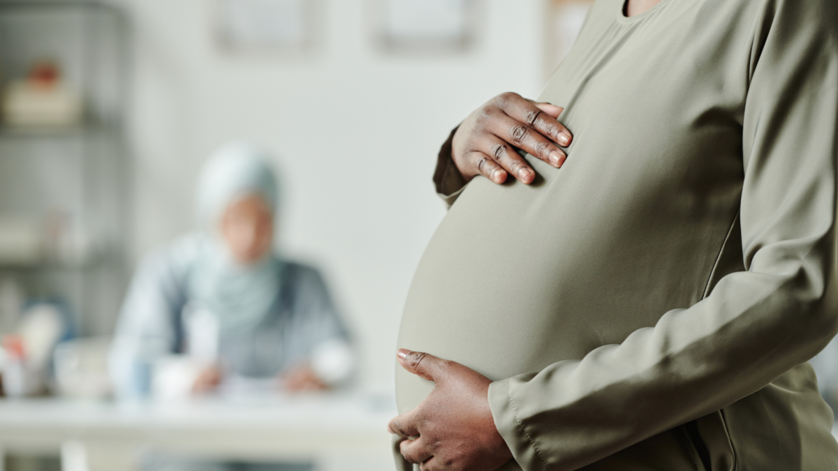 Pregnant woman holding her belly at a pregnancy resource center, illustrating First Amendment donor privacy case