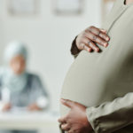 Pregnant woman holding her belly at a pregnancy resource center, illustrating First Amendment donor privacy case