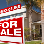 A "Tax Sale" or public auction notice posted on the front lawn or door of a modest single-family home. Another option is a county auction room with bidder paddles raised.